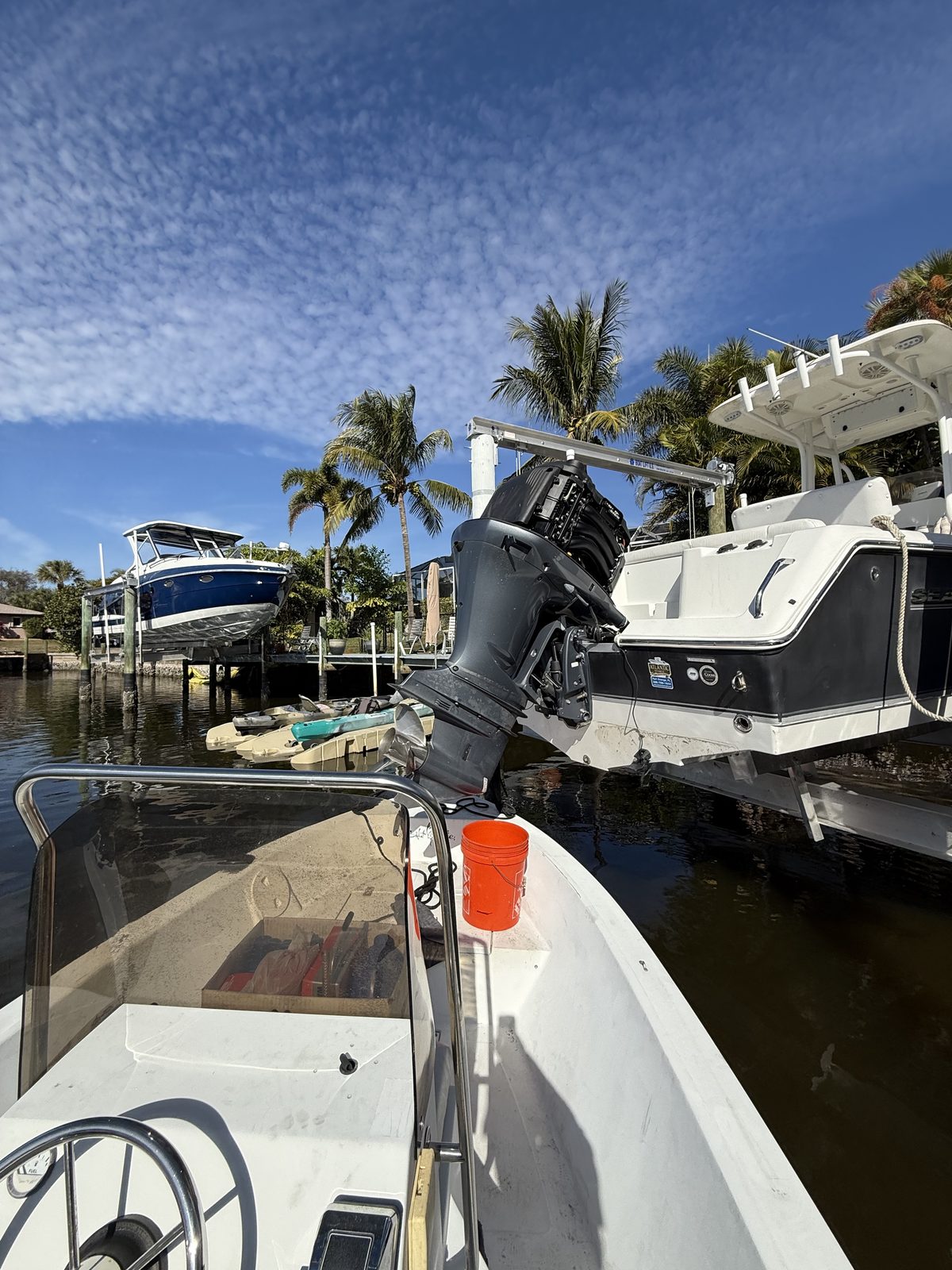Center console boat outboard motor inspection at a residential dock